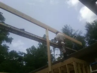 Carpenter setting a ridge beam over a new addition frame — Ice Dam Removal by Roofing Brothers in Rangely