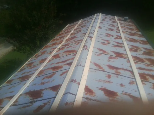 Rusted metal roof panels with new wood purlins before replacement — Storm Damage Roof Repair in Rangely by Roofing Brothers