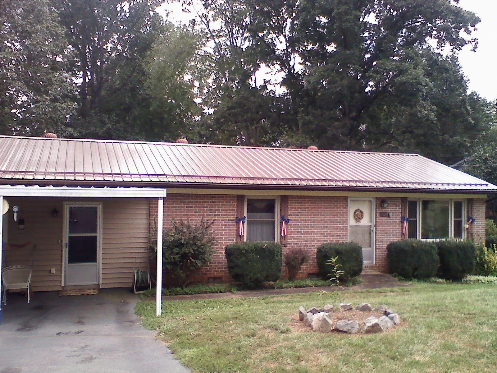 Bronze metal roof and carport on a brick ranch home — Roof Repair work by our crew in Rangely