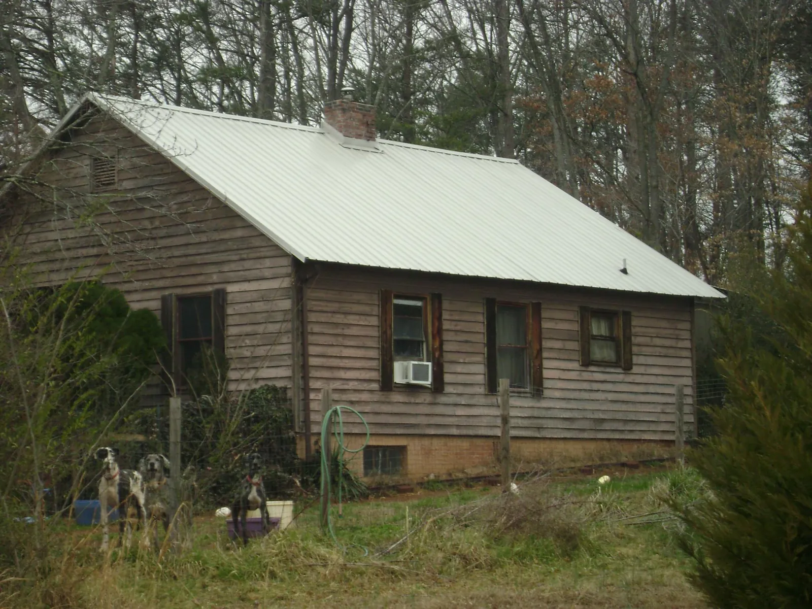 White metal roof on an old wood sided farmhouse, from a Metal Roof Installation job in Rangely